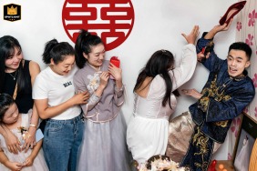 The groom rushes to retrieve his wedding shoes during a playful game at a home in Taiyuan, Shanxi, China